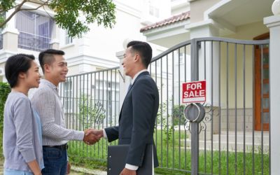 Agen properti dan klien sedang berada di depan rumah.