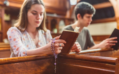 Dua orang sedang beribadah di gereja.