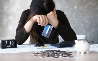 Seorang wanita dengan hutang kartu kredit dan tagihan di atas meja (www.freepik.com)