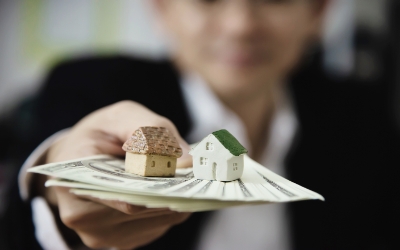 Seorang pria menyodorkan uang dan miniatur rumah (www.freepik.com)